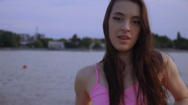 Sahilde dans eden seksi kız. Güzel bir kadın kalçasıyla kumda dans eder. Bikinili seksi kadın. Bikinili genç bir kadın kumların üzerinde enerjik bir dans ediyor..