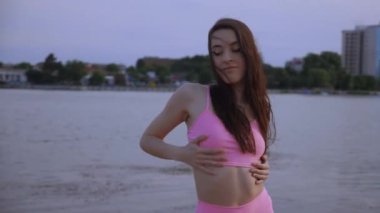 Sahilde dans eden seksi kız. Güzel bir kadın kalçasıyla kumda dans eder. Bikinili seksi kadın. Bikinili genç bir kadın kumların üzerinde enerjik bir dans ediyor..