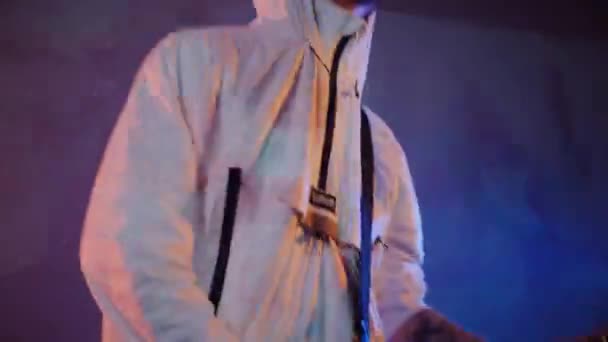一个男人在演播室里弹电吉他 驾驶音乐家吉他手在白色吉他手上玩摇滚 工作室 彩色背景 穿着白色连帽衫的音乐家在弹电吉他 身穿白色连帽衫 弹奏电吉他的吉他手 — 图库视频影像