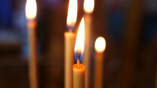 一排排点燃的蜡烛在昏暗的教堂里 在礼拜场所里 蜡烛发出温暖的光芒 蜡烛在一个神圣的空间里燃烧得很明亮 点亮蜡烛 营造和平气氛 — 图库视频影像