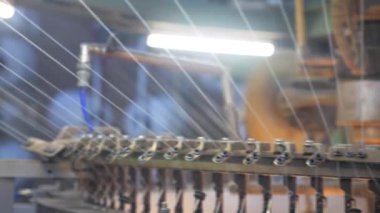 Arabalarda kumaş dokuma. Fabrikadaki ipliklerden kumaş üretimi. Tekstil fabrikası endüstrisi. Kumaş yapan makineler. Fabrikada iplik döndürme makinesi. Endüstriyel iplik dönüyor. Fabrika ortamında otomatik iplik üretimi
