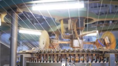 Arabalarda kumaş dokuma. Fabrikadaki ipliklerden kumaş üretimi. Tekstil fabrikası endüstrisi. Kumaş yapan makineler. Fabrikada iplik döndürme makinesi. Endüstriyel iplik dönüyor. Fabrika ortamında otomatik iplik üretimi