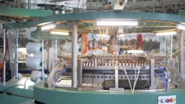 Arabalarda kumaş dokuma. Fabrikadaki ipliklerden kumaş üretimi. Tekstil fabrikası endüstrisi. Kumaş yapan makineler. Fabrikada iplik döndürme makinesi. Endüstriyel iplik dönüyor. Fabrika ortamında otomatik iplik üretimi