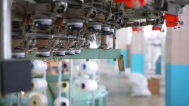 Arabalarda kumaş dokuma. Fabrikadaki ipliklerden kumaş üretimi. Tekstil fabrikası endüstrisi. Kumaş yapan makineler. Fabrikada iplik döndürme makinesi. Endüstriyel iplik dönüyor. Fabrika ortamında otomatik iplik üretimi