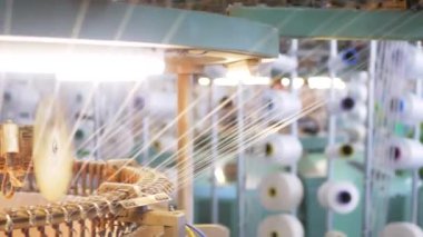 Arabalarda kumaş dokuma. Fabrikadaki ipliklerden kumaş üretimi. Tekstil fabrikası endüstrisi. Kumaş yapan makineler. Fabrikada iplik döndürme makinesi. Endüstriyel iplik dönüyor. Fabrika ortamında otomatik iplik üretimi
