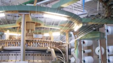 Arabalarda kumaş dokuma. Fabrikadaki ipliklerden kumaş üretimi. Tekstil fabrikası endüstrisi. Kumaş yapan makineler. Fabrikada iplik döndürme makinesi. Endüstriyel iplik dönüyor. Fabrika ortamında otomatik iplik üretimi
