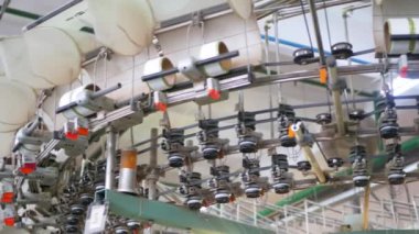 Arabalarda kumaş dokuma. Fabrikadaki ipliklerden kumaş üretimi. Tekstil fabrikası endüstrisi. Kumaş yapan makineler. Fabrikada iplik döndürme makinesi. Endüstriyel iplik dönüyor. Fabrika ortamında otomatik iplik üretimi