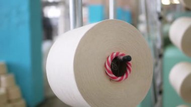 Arabalarda kumaş dokuma. Fabrikadaki ipliklerden kumaş üretimi. Tekstil fabrikası endüstrisi. Kumaş yapan makineler. Fabrikada iplik döndürme makinesi. Endüstriyel iplik dönüyor. Fabrika ortamında otomatik iplik üretimi