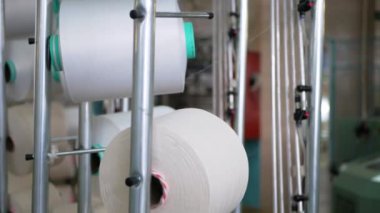 Arabalarda kumaş dokuma. Fabrikadaki ipliklerden kumaş üretimi. Tekstil fabrikası endüstrisi. Kumaş yapan makineler. Fabrikada iplik döndürme makinesi. Endüstriyel iplik dönüyor. Fabrika ortamında otomatik iplik üretimi