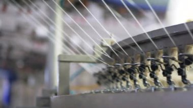 Arabalarda kumaş dokuma. Fabrikadaki ipliklerden kumaş üretimi. Tekstil fabrikası endüstrisi. Kumaş yapan makineler. Fabrikada iplik döndürme makinesi. Endüstriyel iplik dönüyor. Fabrika ortamında otomatik iplik üretimi