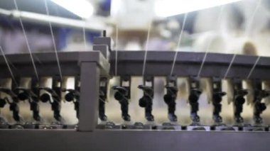 Arabalarda kumaş dokuma. Fabrikadaki ipliklerden kumaş üretimi. Tekstil fabrikası endüstrisi. Kumaş yapan makineler. Fabrikada iplik döndürme makinesi. Endüstriyel iplik dönüyor. Fabrika ortamında otomatik iplik üretimi