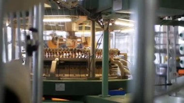 Arabalarda kumaş dokuma. Fabrikadaki ipliklerden kumaş üretimi. Tekstil fabrikası endüstrisi. Kumaş yapan makineler. Fabrikada iplik döndürme makinesi. Endüstriyel iplik dönüyor. Fabrika ortamında otomatik iplik üretimi