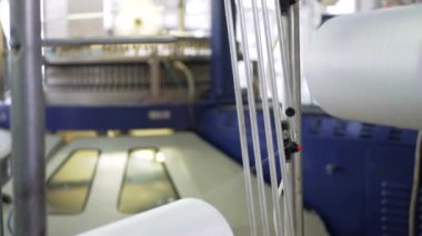 Arabalarda kumaş dokuma. Fabrikadaki ipliklerden kumaş üretimi. Tekstil fabrikası endüstrisi. Kumaş yapan makineler. Fabrikada iplik döndürme makinesi. Endüstriyel iplik dönüyor. Fabrika ortamında otomatik iplik üretimi