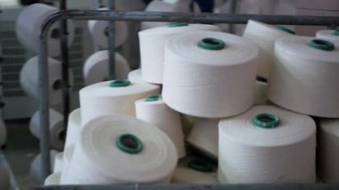 Arabalarda kumaş dokuma. Fabrikadaki ipliklerden kumaş üretimi. Tekstil fabrikası endüstrisi. Kumaş yapan makineler. Fabrikada iplik döndürme makinesi. Endüstriyel iplik dönüyor. Fabrika ortamında otomatik iplik üretimi
