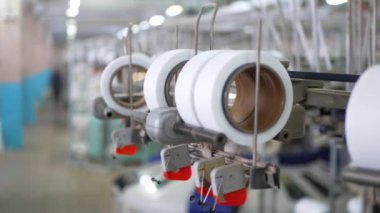 Arabalarda kumaş dokuma. Fabrikadaki ipliklerden kumaş üretimi. Tekstil fabrikası endüstrisi. Kumaş yapan makineler. Fabrikada iplik döndürme makinesi. Endüstriyel iplik dönüyor. Fabrika ortamında otomatik iplik üretimi