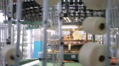 Arabalarda kumaş dokuma. Fabrikadaki ipliklerden kumaş üretimi. Tekstil fabrikası endüstrisi. Kumaş yapan makineler. Fabrikada iplik döndürme makinesi. Endüstriyel iplik dönüyor. Fabrika ortamında otomatik iplik üretimi