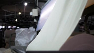 Arabalarda kumaş dokuma. Fabrikadaki ipliklerden kumaş üretimi. Tekstil fabrikası endüstrisi. Kumaş yapan makineler. Fabrikada iplik döndürme makinesi. Endüstriyel iplik dönüyor. Fabrika ortamında otomatik iplik üretimi