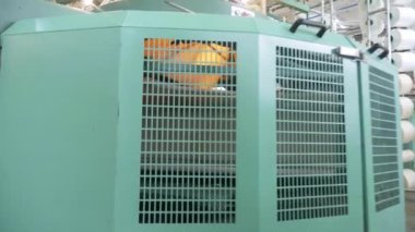 Arabalarda kumaş dokuma. Fabrikadaki ipliklerden kumaş üretimi. Tekstil fabrikası endüstrisi. Kumaş yapan makineler. Fabrikada iplik döndürme makinesi. Endüstriyel iplik dönüyor. Fabrika ortamında otomatik iplik üretimi