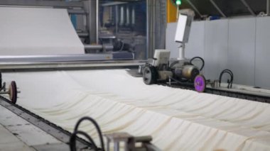Arabalarda kumaş dokuma. Fabrikadaki ipliklerden kumaş üretimi. Tekstil fabrikası endüstrisi. Kumaş yapan makineler. Fabrikada iplik döndürme makinesi. Endüstriyel iplik dönüyor. Fabrika ortamında otomatik iplik üretimi