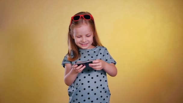 Маленькая Девочка Солнечных Очках Играет Игру Мобильном Телефоне Молодая Девушка — стоковое видео