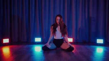 Yüksek topuklularla dans eden seksi kadın. Bir dansçı kız karanlık bir salonda erotik bir şekilde dans eder. Twerk, yüksek topuklar, striptiz, baştan çıkarıcı bir dans. Balık ağı çoraplı baştan çıkarıcı kadın yerde poz veriyor. Balık ağı çoraplı kadın yerde kendine güvenini sergiliyor.. 