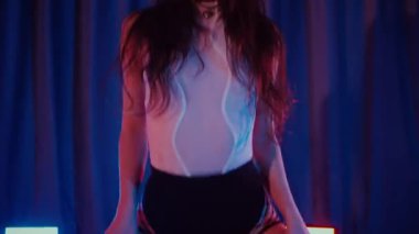 Yüksek topuklularla dans eden seksi kadın. Bir dansçı kız karanlık bir salonda erotik bir şekilde dans eder. Twerk, yüksek topuklar, striptiz, baştan çıkarıcı bir dans. Balık ağı çoraplı baştan çıkarıcı kadın yerde poz veriyor. Balık ağı çoraplı kadın yerde kendine güvenini sergiliyor.. 