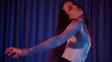 Yüksek topuklularla dans eden seksi kadın. Bir dansçı kız karanlık bir salonda erotik bir şekilde dans eder. Twerk, yüksek topuklar, striptiz, baştan çıkarıcı bir dans. Balık ağı çoraplı baştan çıkarıcı kadın yerde poz veriyor. Balık ağı çoraplı kadın yerde kendine güvenini sergiliyor.. 