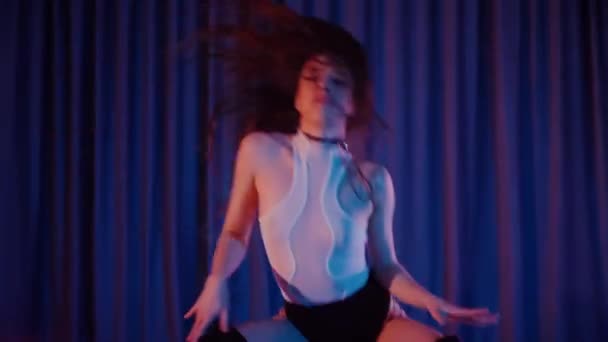 ハイヒールで踊るセクシーな女性 ダンサーの女の子がダークホールでエロチックに踊る ハイヒール ストリップテース 魅惑的なダンス 魚網のストッキングの魅惑的な女性は床にポーズします 魚網のストッキングの女性は床に彼女の自信を欠いている — ストック動画