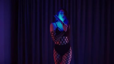 Elinde fenerlerle dans eden seksi bir kadın. Bir dansçı kız karanlık bir salonda erotik bir şekilde dans eder. Yavaş çekim. Twerk, yüksek topuklar, striptiz, baştan çıkarıcı bir dans. Balık ağı çoraplı bir kadın ahşap zeminde boğucu bir poz veriyor..