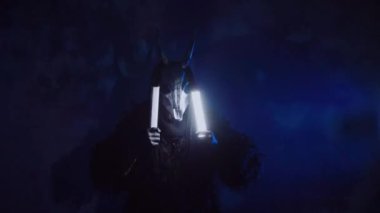 Şeytan canavar elinde RGB çubuklarıyla dans ediyor. Karanlık bir stüdyoda maskeli gizemli bir adam. Adam siyah bir ceket ve boynuzlu bir maske giymiş. Uzaylı uzaylı. Korkunç.,