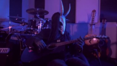 Şeytan canavar gitar çalıyor. Karanlık bir stüdyoda maskeli gizemli bir adam. Korku, Cadılar Bayramı, Cehennem