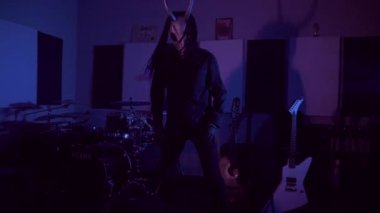 Şeytan canavar dans ediyor. Karanlık bir stüdyoda maskeli gizemli bir adam. Adam siyah bir ceket ve boynuzlu bir maske giymiş. Uzaylı uzaylı. Korkunç.,