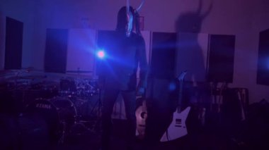 Şeytan canavar dans ediyor. Karanlık bir stüdyoda maskeli gizemli bir adam. Adam siyah bir ceket ve boynuzlu bir maske giymiş. Uzaylı uzaylı. Korkunç.,