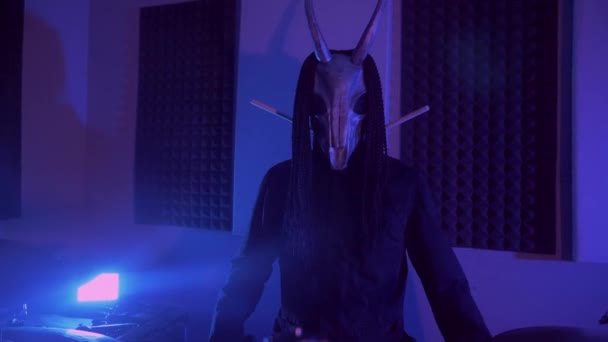 魔鬼怪物在打鼓 一个戴着可怕面具的神秘男人在黑暗的工作室里恐怖 万圣节 — 图库视频影像