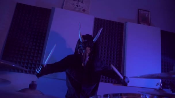 魔鬼怪物在打鼓 一个戴着可怕面具的神秘男人在黑暗的工作室里恐怖 万圣节 — 图库视频影像