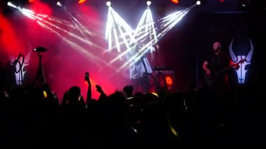 Kulüpte rock konseri. Gece kulübü partisi. Rock grubu rock festivalinde çalıyor. Konserdeki bir grup insan heyecanla ellerini kaldırdı. Kollarını kaldırıp canlı müziğin keyfini çıkarıyorlar. Taraftarlar dans ediyor ve konserde coşku gösteriyorlar.