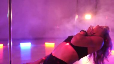 Seksi kadın disko kulübünde direk dansı yapıyor. Direğin üstünde erotik dans. Egzotik direk dansı, striptizci, direk sporu, direk sanatı. Dansçı bir direğin etrafında kıvrılır ve döner. Baştan çıkarıcı striptizci akışkan hareketleriyle gölgelerde büyülenir..