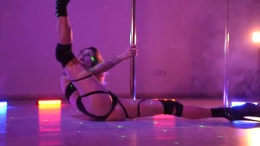 Seksi kadın disko kulübünde direk dansı yapıyor. Direğin üstünde erotik dans. Egzotik direk dansı, striptizci, direk sporu, direk sanatı. Dansçı bir direğin etrafında kıvrılır ve döner. Baştan çıkarıcı striptizci akışkan hareketleriyle gölgelerde büyülenir..