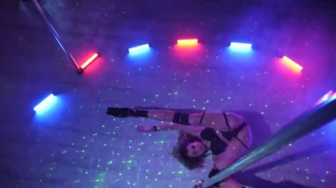 Seksi kadın disko kulübünde direk dansı yapıyor. Direğin üstünde erotik dans. Egzotik direk dansı, striptizci, direk sporu, direk sanatı. Dansçı bir direğin etrafında kıvrılır ve döner. Baştan çıkarıcı striptizci akışkan hareketleriyle gölgelerde büyülenir..