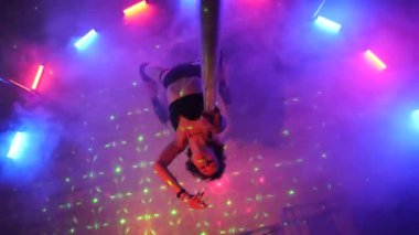Seksi kadın disko kulübünde direk dansı yapıyor. Direğin üstünde erotik dans. Egzotik direk dansı, striptizci, direk sporu, direk sanatı. Dansçı bir direğin etrafında kıvrılır ve döner. Baştan çıkarıcı striptizci akışkan hareketleriyle gölgelerde büyülenir..