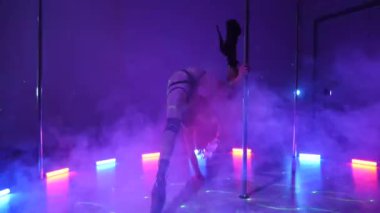 Seksi kadın disko kulübünde direk dansı yapıyor. Direğin üstünde erotik dans. Egzotik direk dansı, striptizci, direk sporu, direk sanatı. Dansçı bir direğin etrafında kıvrılır ve döner. Baştan çıkarıcı striptizci akışkan hareketleriyle gölgelerde büyülenir..