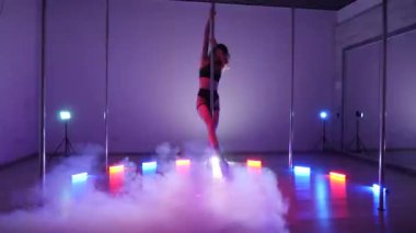 Seksi kadın disko kulübünde direk dansı yapıyor. Direğin üstünde erotik dans. Egzotik direk dansı, striptizci, direk sporu, direk sanatı. Dansçı bir direğin etrafında kıvrılır ve döner. Baştan çıkarıcı striptizci akışkan hareketleriyle gölgelerde büyülenir..