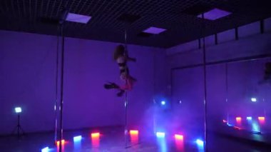 Seksi kadın disko kulübünde direk dansı yapıyor. Direğin üstünde erotik dans. Egzotik direk dansı, striptizci, direk sporu, direk sanatı. Dansçı bir direğin etrafında kıvrılır ve döner. Baştan çıkarıcı striptizci akışkan hareketleriyle gölgelerde büyülenir..