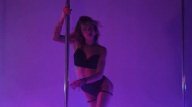 Seksi kadın disko kulübünde direk dansı yapıyor. Direğin üstünde erotik dans. Egzotik direk dansı, striptizci, direk sporu, direk sanatı. Dansçı bir direğin etrafında kıvrılır ve döner. Baştan çıkarıcı striptizci akışkan hareketleriyle gölgelerde büyülenir..