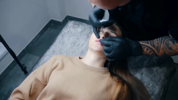 扩大唇的程序 女性唇 男外科医生用注射器小心地 慢慢地将透明质酸注入妇女的嘴唇 注射美容品整形手术 — 图库视频影像