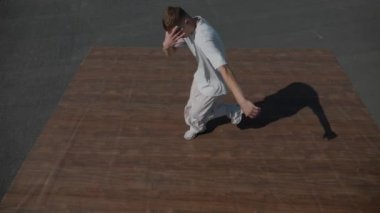 Adam evin çatısında serin kanlılıkla break dans yapıyor. Bir adam enerjik bir atletik dans eder. Adam çatıda dans ederken hiç zorlanmadan break dans yapıyor. Şehir dansçısı çatıda hünerlerini gösteriyor. Breakdansçı yeteneklerini şehrin üzerinde sergiliyor.. 