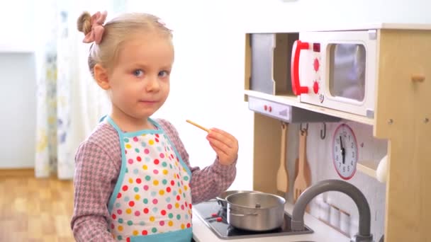 Ahşap Mutfak Setiyle Yemek Yapıyormuş Gibi Yapan Küçük Bir Kız — Stok video