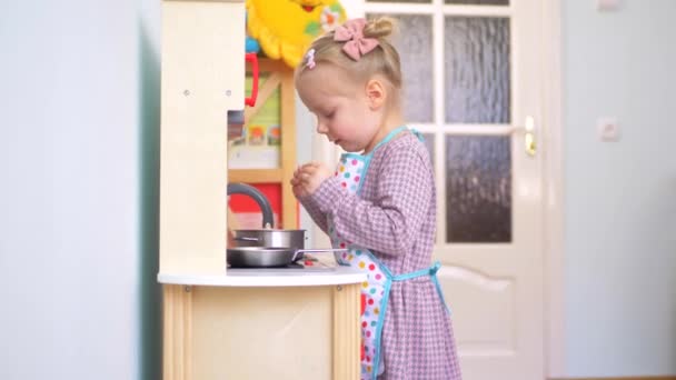 Seorang Gadis Kecil Berpura Pura Memasak Dengan Satu Set Dapur — Stok Video