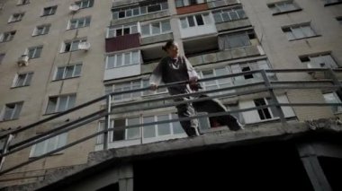 Kız şehir caddesinde serin kanlı hip-hop dansı yapıyor. Bir dansçı bir şehir evinin yakınında dans eder. Gri gömlekli kadın merdivenlerde numaralar yapıyor. Merdivenlerde gösteriş yapan kız. Merdivenlerde gri tişörtlü bir sokak sanatçısı. Gri gömlekli bir kadının merdiven numaraları..
