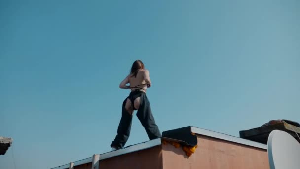 水着の女の子が屋根の上で踊っている ボトルダンス ブートシェイク ハイヒール ヒップホップ エロチックに踊る女性 若い女の子はエネルギー的にセクシーなダンスを踊っています 若い女の子 セクシー ダンス — ストック動画